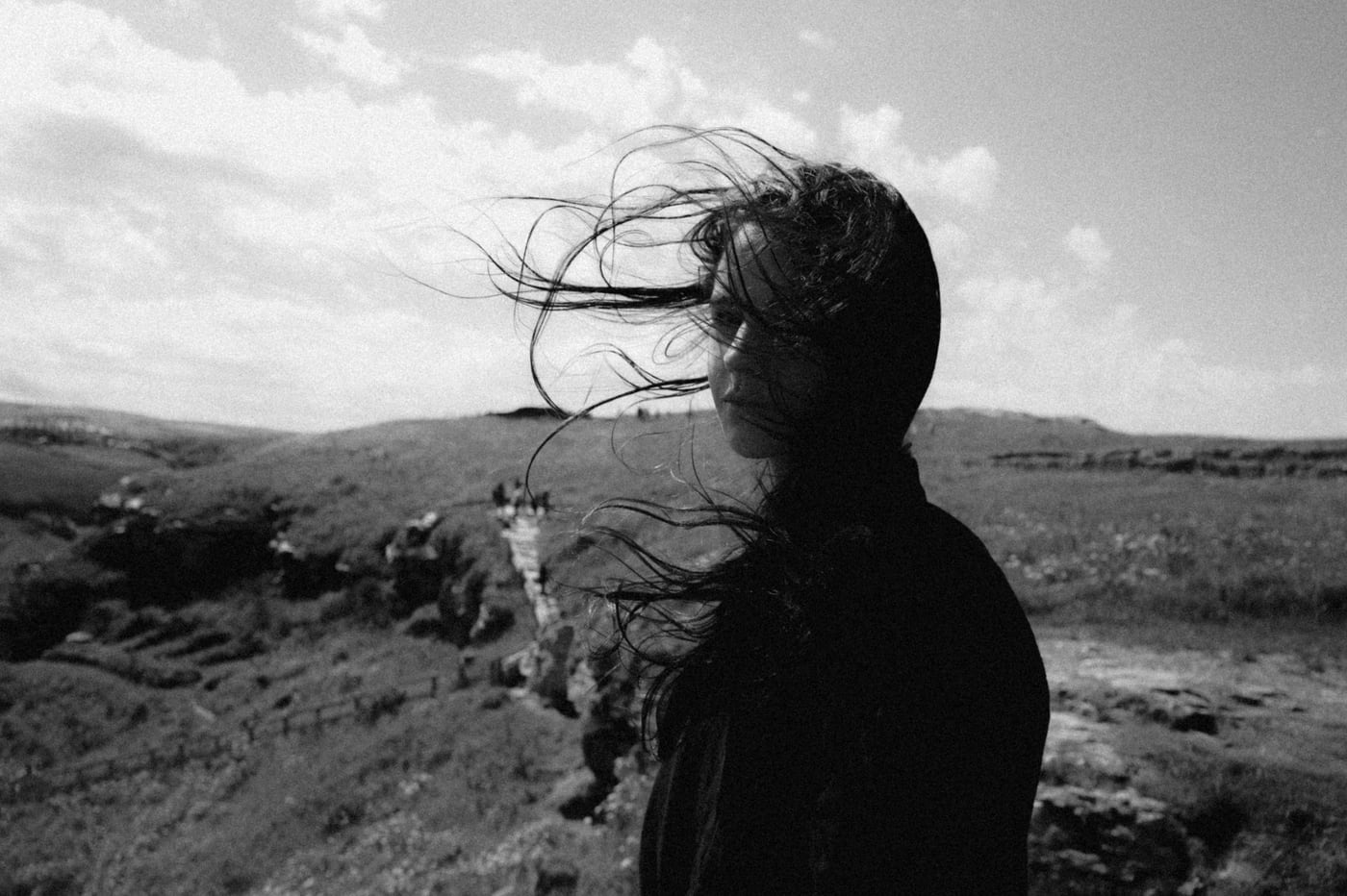 Elena Taber on a coastal hillside, hair caught in the wind